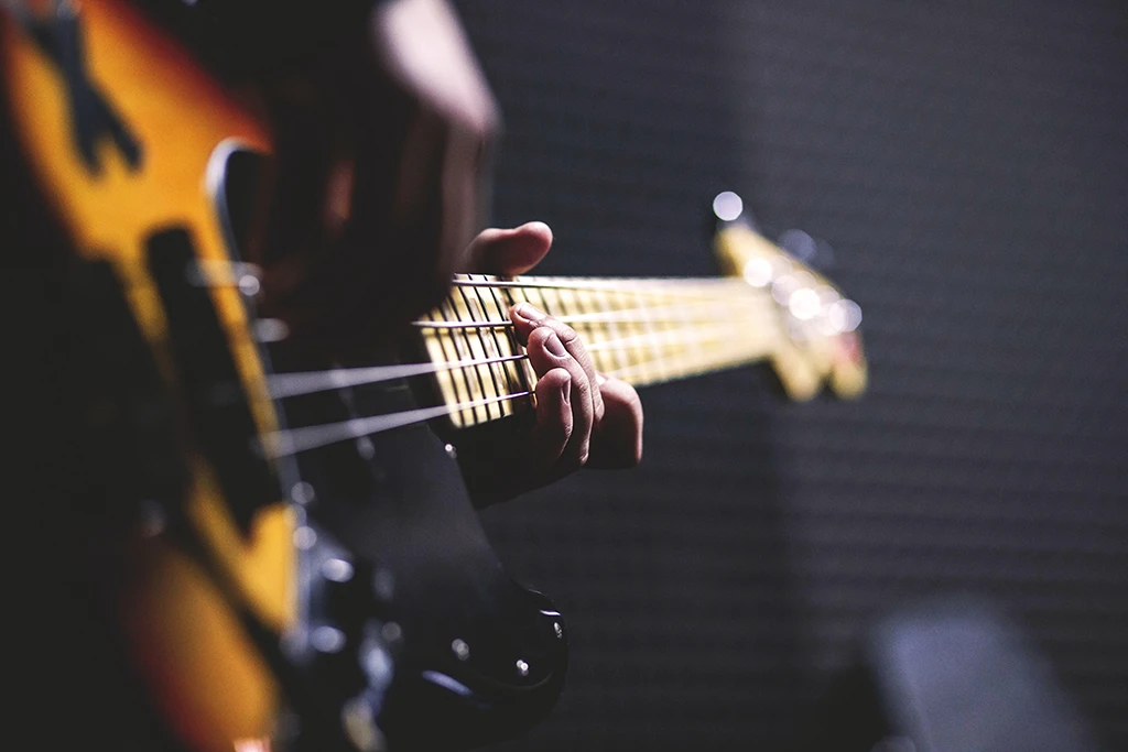 Fokus auf Hände, die an einer Gitarre spielen